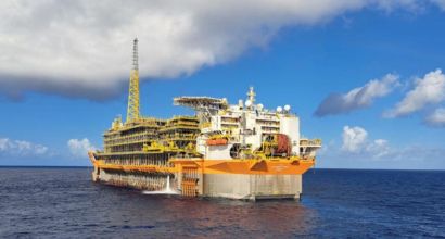 Fotografia diurna de uma plataforma de petróleo no oceano.