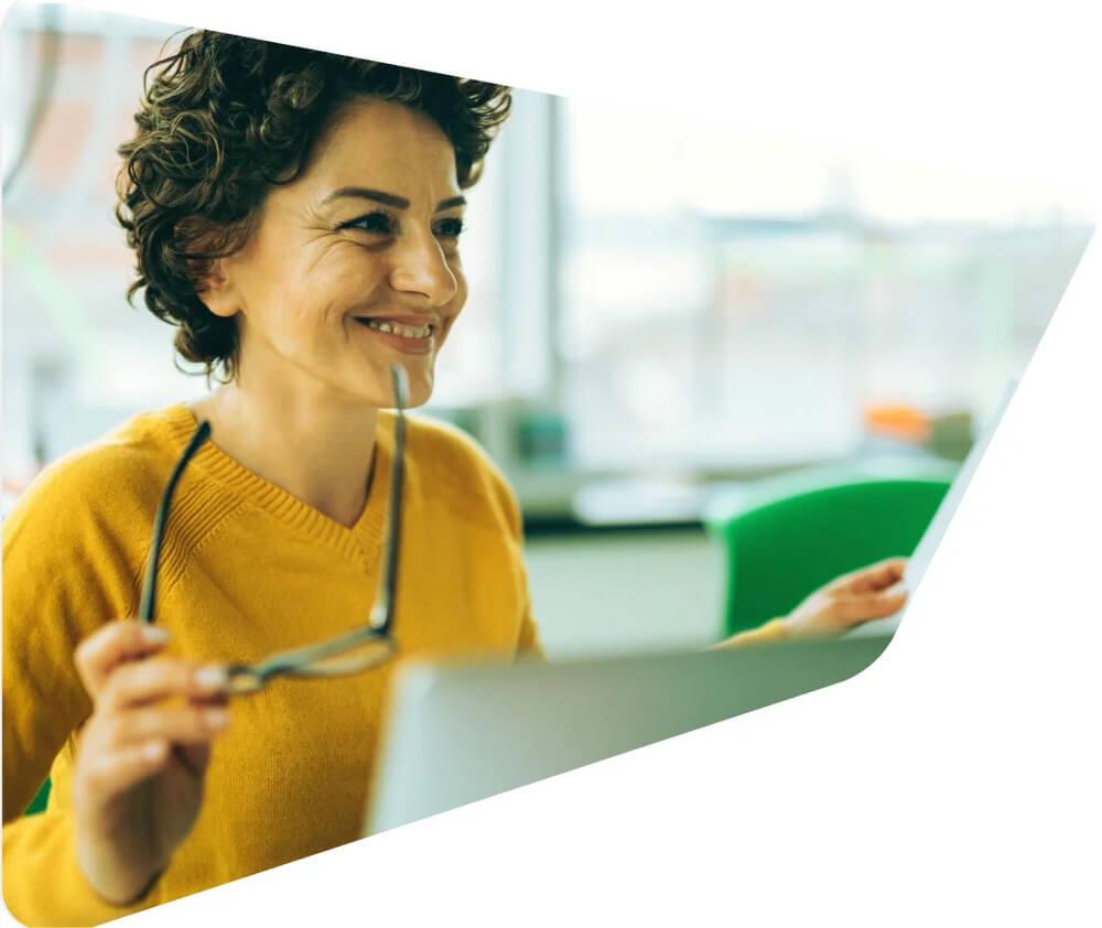 Smiling woman holding her eyeglasses while learning about the Petrobras' Code of Conduct