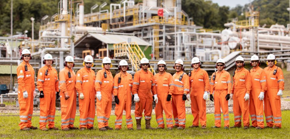 Equipo de Petrobras con monos naranjas y cascos de seguridad en una zona industrial de Bolivia.