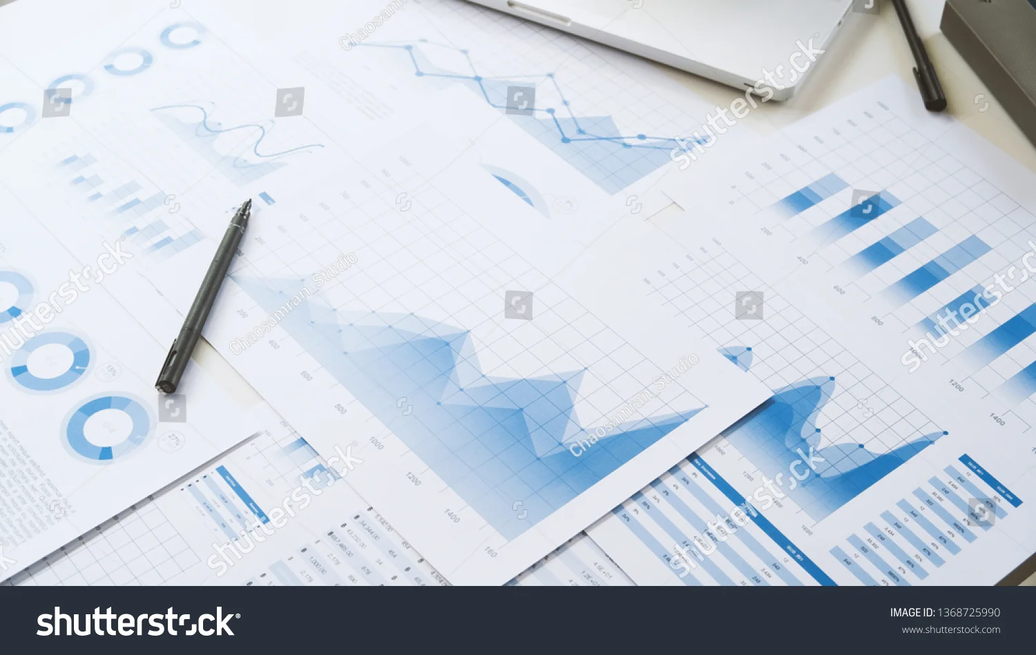 Photo of various annual reports with assorted graphs laid out on a table.